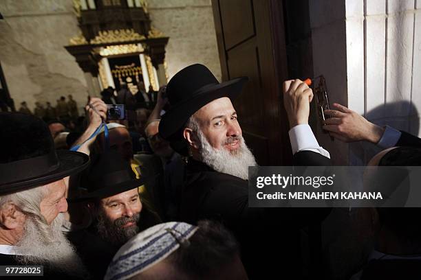 Yona Metzger, the Ashkenazi chief rabbi of Israel, places at the entrance of the Hurva synagogue a mezuza -- the parchment scroll inscribed with a...