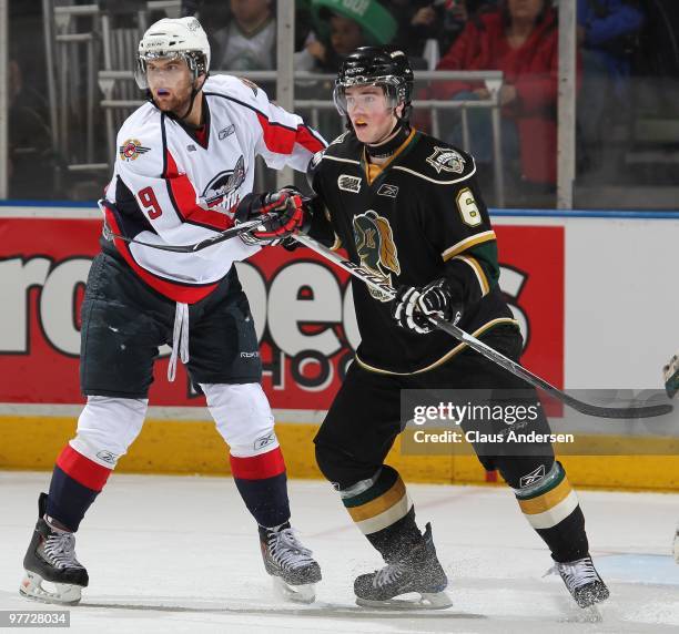 Zack Kassian of the Windsor Spitfires battles with Scott Harrington of the London Knights in a game on March 12, 2010 at the John Labatt Centre in...