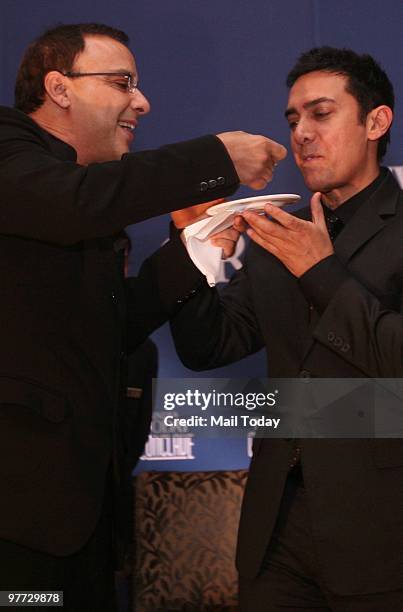 Vidhu Vinod Chopra gives Aamir Khan a piece of his birthday cake at the dinner party hosted after the India Today Conclave ended in New Delhi on...