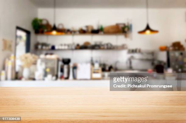 close-up of wooden table against kitchen - table stock-fotos und bilder