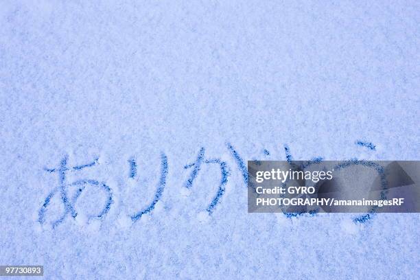 'arigato' in japanese characters written into the snow - creative rf stock-fotos und bilder