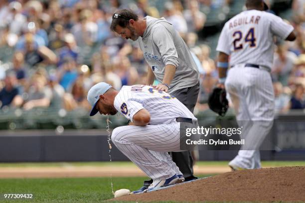 Adrian Houser of the Milwaukee Brewers vomits on the mound in the eighth inning against the Philadelphia Phillies at Miller Park on June 17, 2018 in...