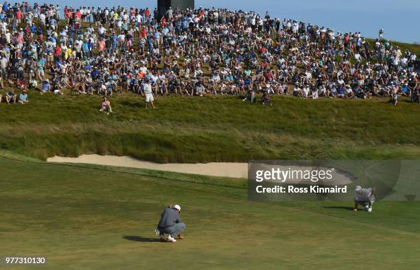 Brooks Koepka of the United States and Dustin Johnson of the United States line up their putts on the 14th green during the final round of the 2018...