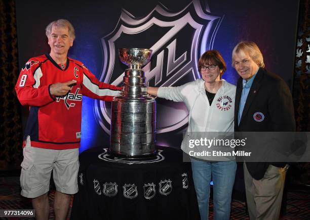 Washington Capitals fans David Frederick and Beth Frederick, both of Colorado, and Keeper of the Cup for the Hockey Hall of Fame Phil Pritchard, pose...