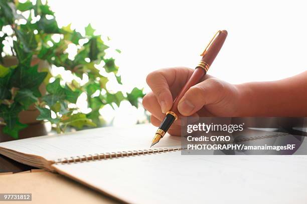 person writing in notebook - creative rf stock-fotos und bilder