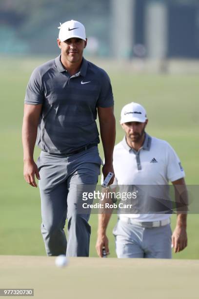 Brooks Koepka of the United States and Dustin Johnson of the United States walk off on the 18th green during the final round of the 2018 U.S. Open at...