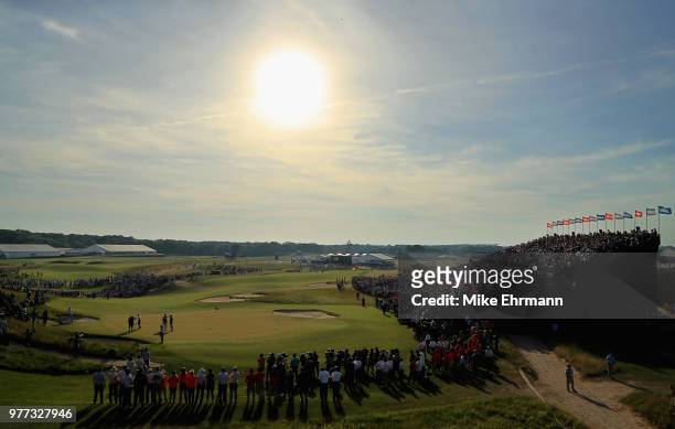 Fans watch Brooks Koepka of the United States and Dustin Johnson of the United States putt on the 18th green during the final round of the 2018 U.S....