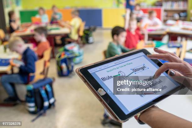 April 2018, Germany, Abensberg: A teacher uses a tablet at the Primary School Offenstetten. The school participares in the project 'Digital School...