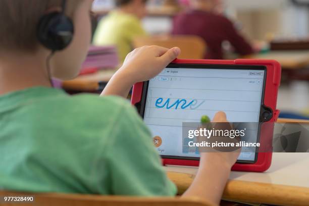 April 2018, Germany, Abensberg: Schoolchildren use tablets in class at the Primary School Offenstetten. The school participares in the project...