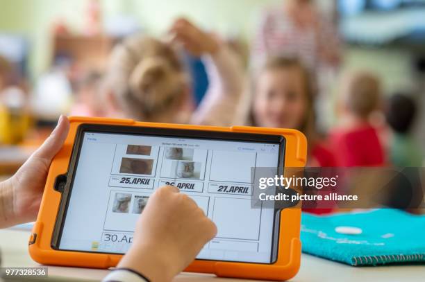 April 2018, Germany, Abensberg: Schoolchildren use tablets in class at the Primary School Offenstetten. The school participares in the project...