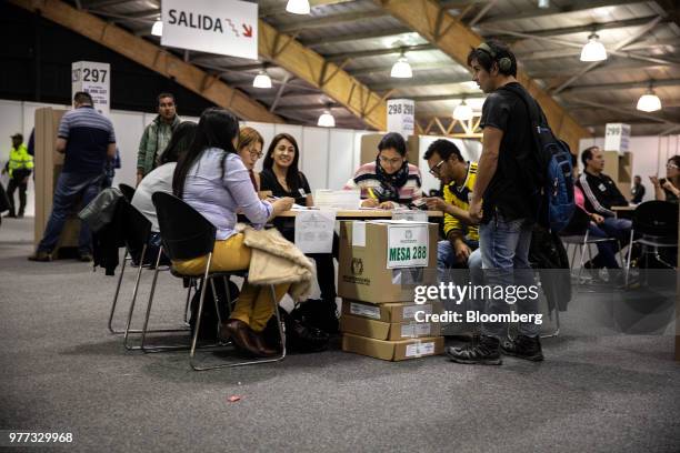 Polling officials verify a voter's identification inside the Corferias polling station during the second round of presidential elections in Bogota,...