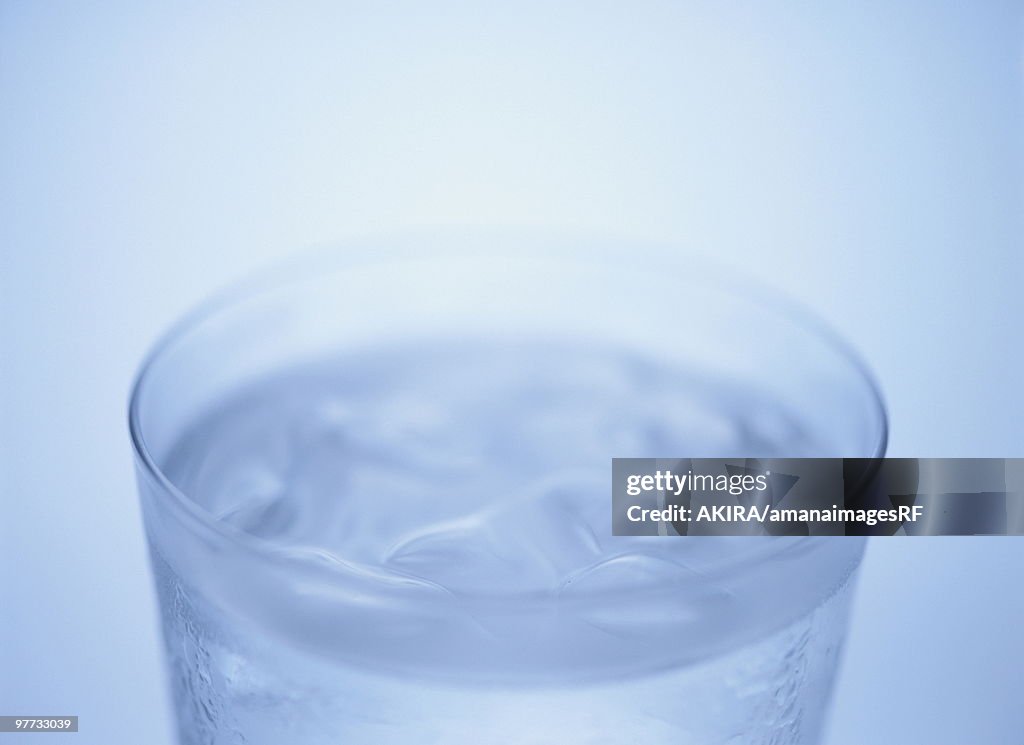 Glass of water, close up, blue background