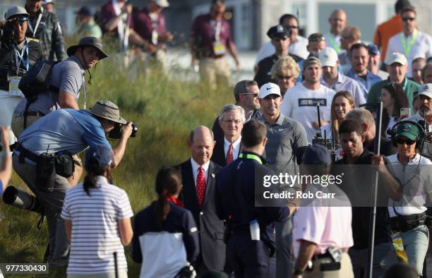 Golf Association CEO Mike Davis and Brooks Koepka of the United States approach the podium for the trophy ceremony after the final round of the 2018...