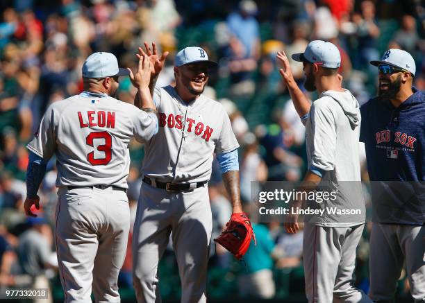 Hector Velazquez of the Boston Red Sox gets a high five from Sandy Leon after closing out the game against the Seattle Mariners at Safeco Field on...