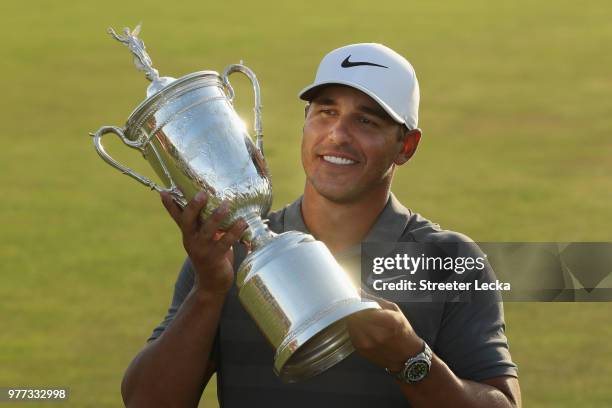 Brooks Koepka of the United States celebrates with the U.S. Open Championship trophy after winning the 2018 U.S. Open at Shinnecock Hills Golf Club...