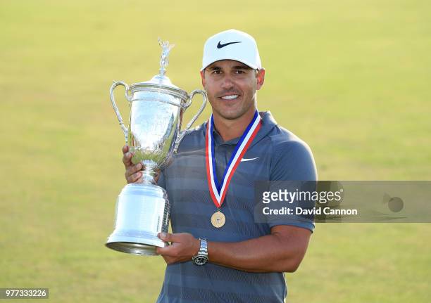 Brooks Koepka of the United States holds the trophy after his one shot victory during the final round of the 2018 US Open at Shinnecock Hills Golf...