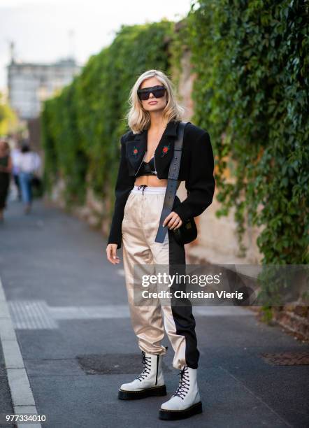 Xenia Adonts wearing boots, jogger pants, cropped jacket is seen outside Palm Angels during Milan Men's Fashion Week Spring/Summer 2019 on June 17,...