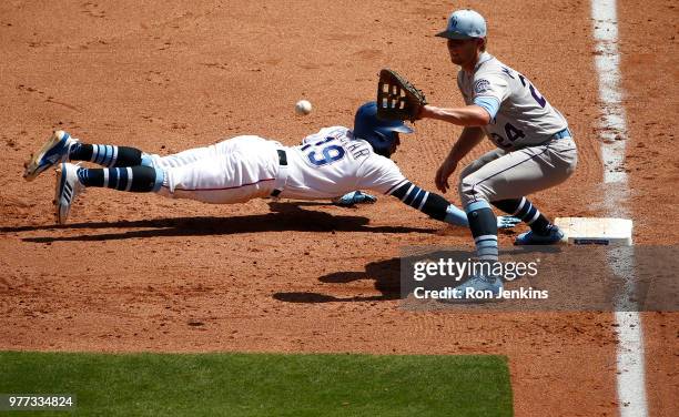 Jurickson Profar of the Texas Rangers dives back safely to first base as Ryan McMahon of the Colorado Rockies takes the throw during the fourth...