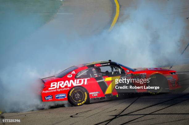 Justin Allgaier, driver of the BRANDT Professional Agriculture Chevrolet, celebrates by doing a burnout after winning the NASCAR Xfinity Series Iowa...