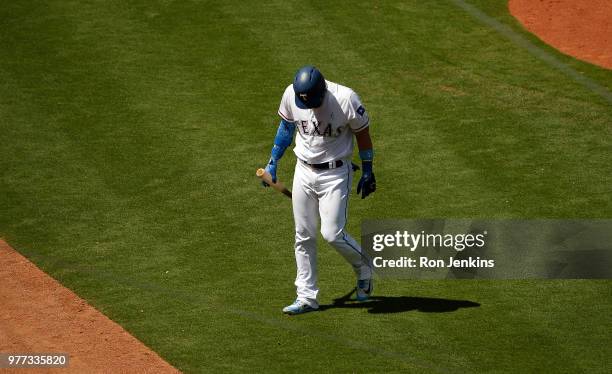 Robinson Chirinos of the Texas Rangers walks back to the dugout after striking out against the Colorado Rockies to end the fifth inning at Globe Life...