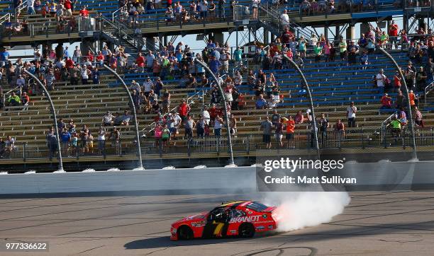 Justin Allgaier, driver of the BRANDT Professional Agriculture Chevrolet, celebrates with a burnout after winning the NASCAR Xfinity Series Iowa 250...