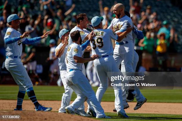 Jonathan Lucroy of the Oakland Athletics celebrates with teammates after hitting a walk off single against the Los Angeles Angels of Anaheim during...