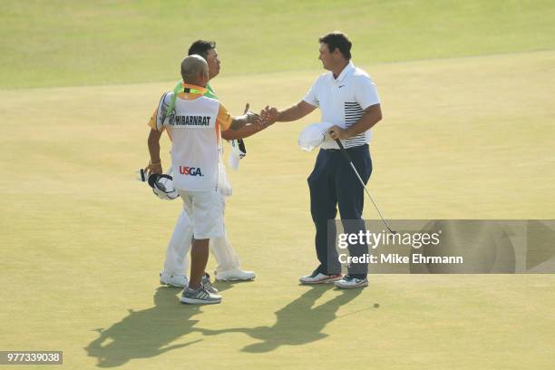 Kiradech Aphibarnrat of Thailand shakes hands with Patrick Reed of the United States on the 18th green during the final round of the 2018 U.S. Open...