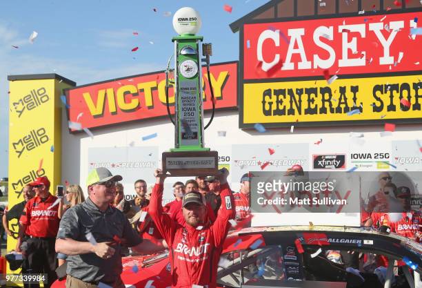 Justin Allgaier, driver of the BRANDT Professional Agriculture Chevrolet, with the trophy after winning the NASCAR Xfinity Series Iowa 250 presented...