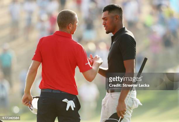 Daniel Berger of the United States and Tony Finau of the United States shake hands on the 18th green after the final round of the 2018 U.S. Open at...