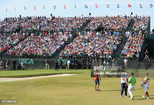 Patrick Reed of the United States and Kiradech Aphibarnrat of Thailand shake hands on the 18th greenduring the final round of the 2018 U.S. Open at...