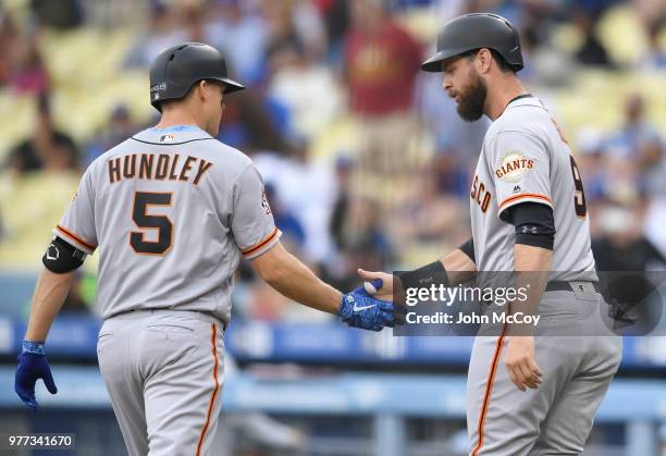 Nick Hundley of the San Francisco Giants is congratulated for his two run home run by Brandon Belt in the first inning against the Los Angeles...