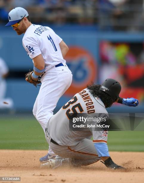 Logan Forsythe of the Los Angeles Dodgers tags second to put out Brandon Crawford of the San Francisco Giants in the eight inning at Dodger Stadium...