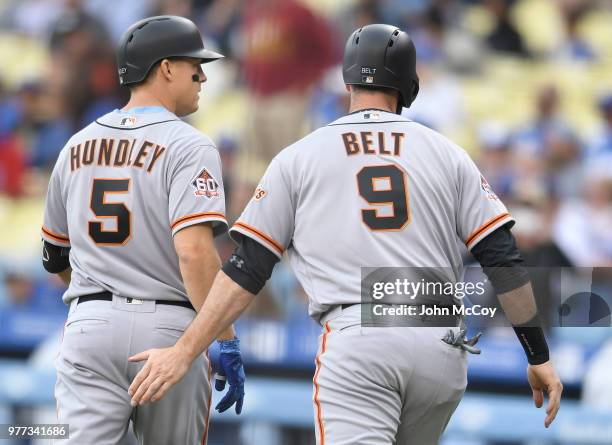 Nick Hundley of the San Francisco Giants is congratulated for his two run home run by Brandon Belt in the first inning against the Los Angeles...