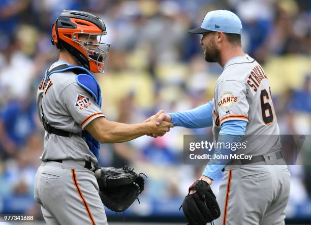 Nick Hundley of the San Francisco Giants shakes hands with Hunter Strickland of the San Francisco Giants after the game against the Los Angeles...