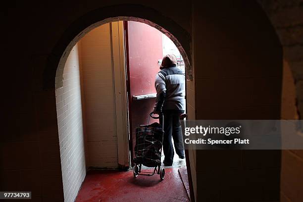 Woman walks out with a basket of food at the food pantry at St. Augustine's Church on March 15, 2010 in the Bronx borough of New York City. The St....