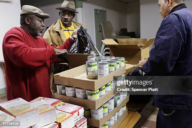 Men place food in bags to be distributed at the food pantry at St. Augustine's Church on March 15, 2010 in the Bronx borough of New York City. The...