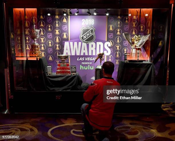 Guest takes photos of the King Clancy Memorial Trophy, the William M. Jennings Trophy, the Ted Lindsay Award and the Maurice "Rocket" Richard Trophy...