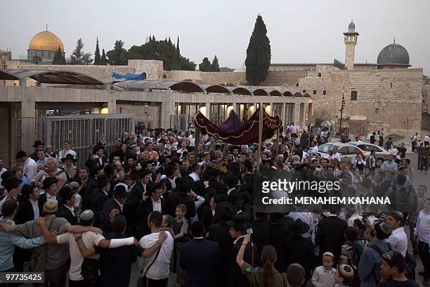 Orthodox Jews dance and march with Torah scrolls during an inauguration ceremony for the holy book from the Western Wall to the newly renovated Hurva...