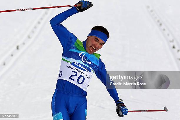 Gold medalist Kirill Mikhaylov of Russia celebrates as he crosses the finish line to win the men's standing 20km free cross-country skiing race...