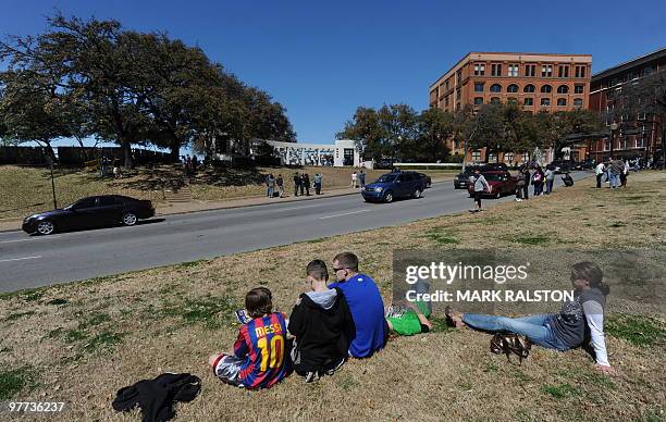 Tourists sit in front of the Grassy Knoll on March 13, 2010 at the spot beside of the former Texas School Book Depository Building in Dealey Plaza,...