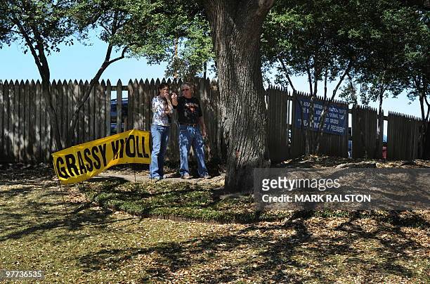 Tourists stand on the Grassy Knoll on March 13 beside the former Texas School Book Depository Building in Dealey Plaza, where the 1963 assasination...