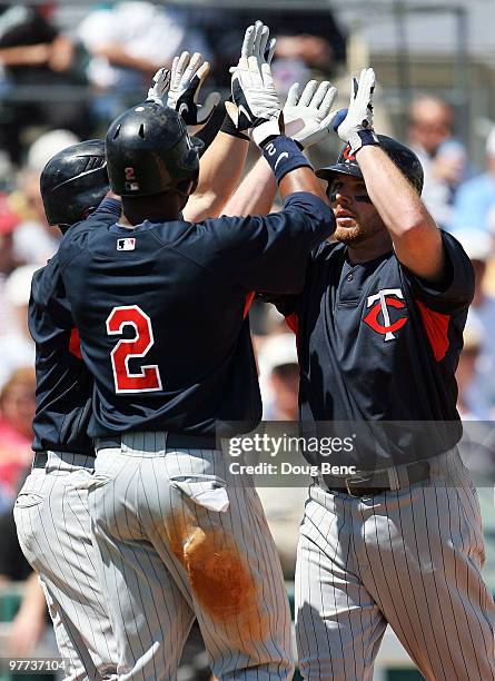 Right fielder Jason Kubel of the Minnesota Twins is congratulated by teammates Nick Punto and Denard Span after his three-run home run against the...