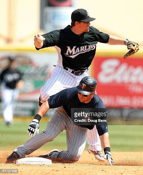 Shortstop Donnie Murphy of the Florida Marlins can't complete a double play after a hard slide by Nick Punto of the Minnesota Twins at Roger Dean...