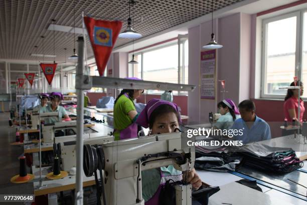 This photo taken on June 12, 2018 shows an employee of the Ryo Won Footwear Factory operating a sewing machine in Pyongyang. - US President Donald...