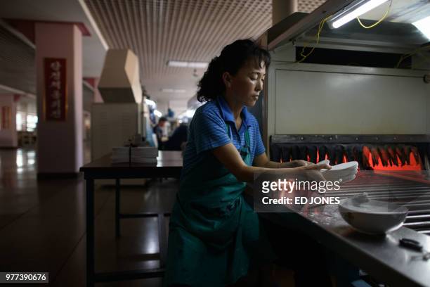 This photo taken on June 12, 2018 shows an employee of the Ryo Won Footwear Factory working on a production line making shoes in Pyongyang. - US...