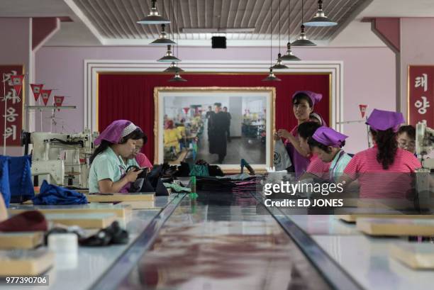 This photo taken on June 12, 2018 shows employees of the Ryo Won Footwear Factory working on a production line making shoes in Pyongyang. US...