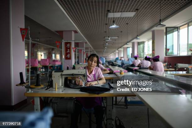 This photo taken on June 12, 2018 shows an employee of the Ryo Won Footwear Factory working on a sewing machine in Pyongyang. - US President Donald...