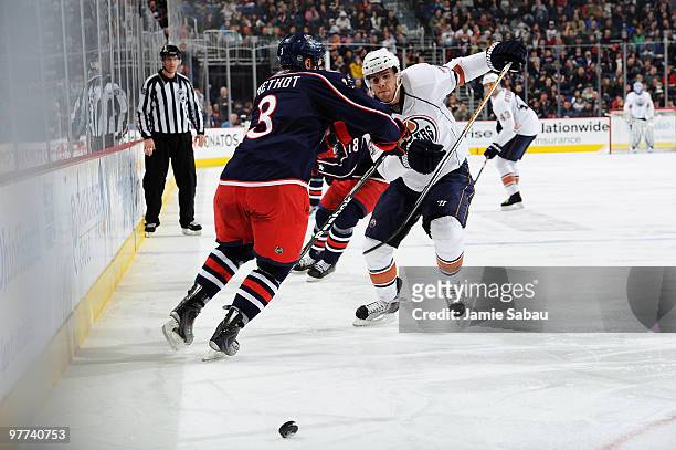 Marc Methot of the Columbus Blue Jackets attempts to keep Marc Pouliot of the Edmonton Oilers from chasing down a loose puck during the second period...