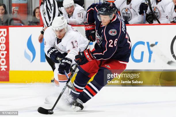 Samuel Pahlsson of the Columbus Blue Jackets and Andrew Cogliano of the Edmonton Oilers battle for control of the puck during the first period on...