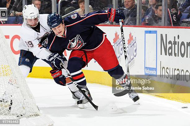 Derek Dorsett of the Columbus Blue Jackets and Sam Gagner of the Edmonton Oilers battle for control of a loose puck behind the net during the third...